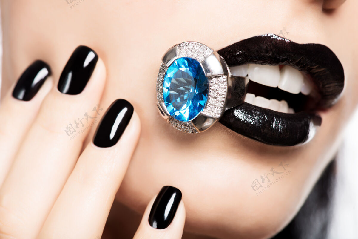 配件一个女人的嘴唇和指甲被涂成亮黑色的宏观照片宏美甲指甲