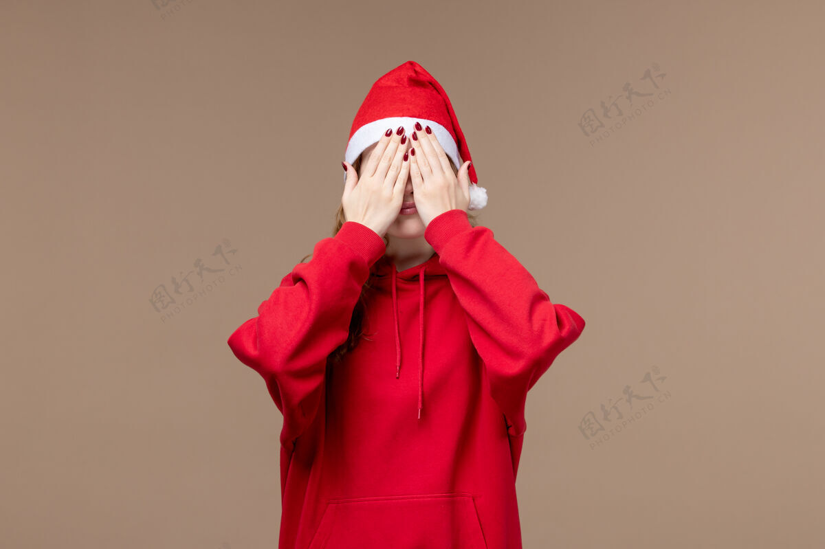 衣服正面图圣诞节女孩覆盖她的脸上棕色背景模型假日圣诞节肖像风衣风衣