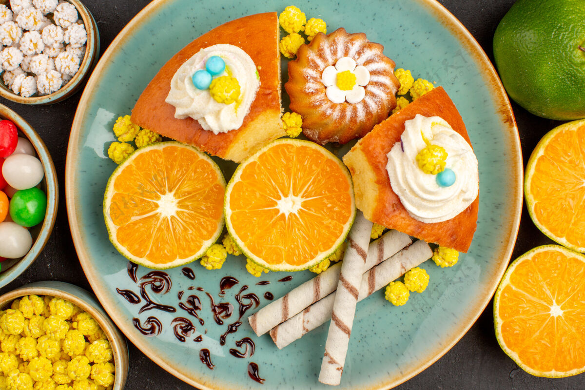 水果顶视图美味蛋糕片与新鲜切片橘子和糖果在黑暗中健康的水果蛋糕
