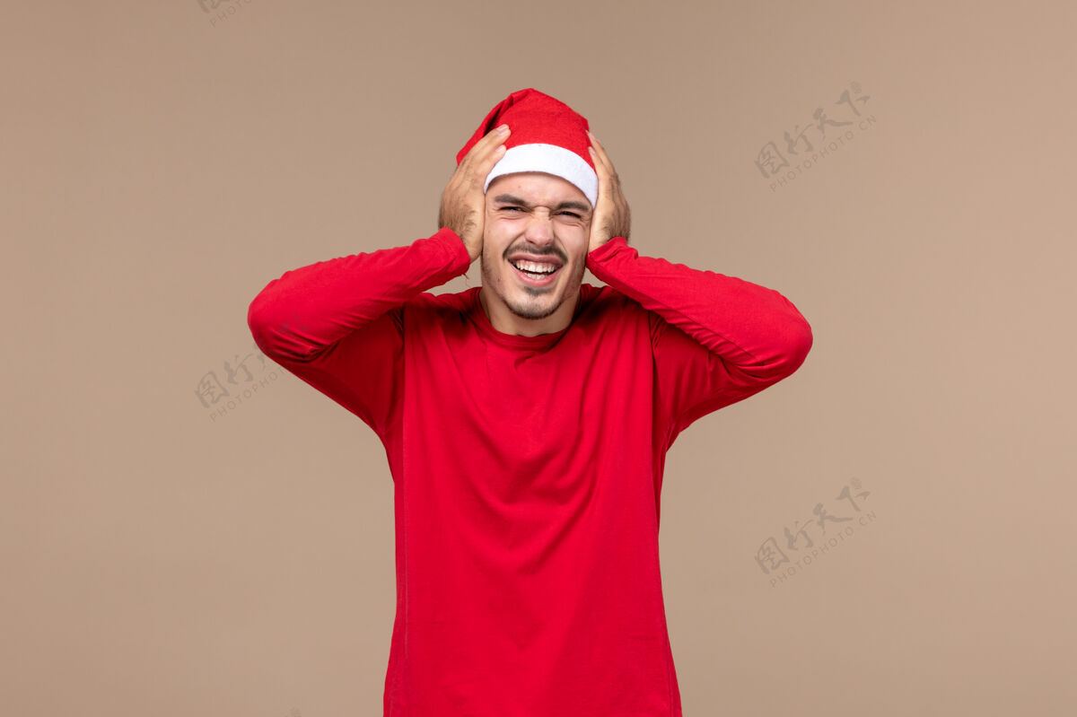 帽子正面图棕色背景上表情激动的年轻男性圣诞假期感慨成人漂亮背景
