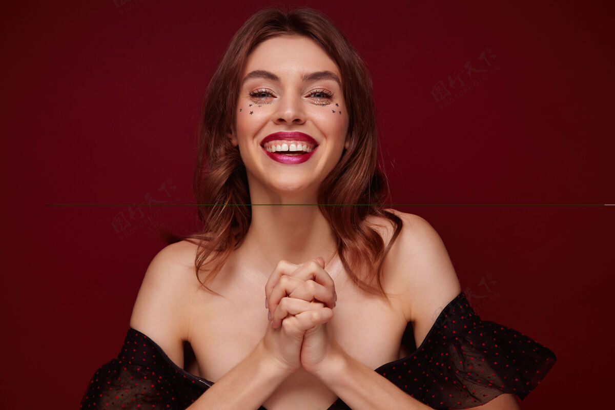 微笑一幅正面的年轻可爱的棕色头发的女性肖像 身着节日服装 开心地看着镜头 面带微笑 交叉着双臂 站在红葡萄酒的背景下红葡萄酒发型漂亮