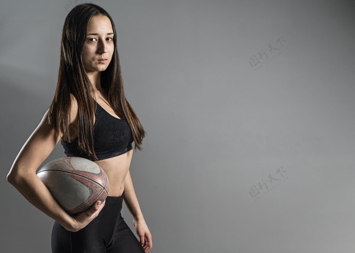 比赛女橄榄球运动员与球和复制空间摆姿势的侧视图比赛复制空间活动
