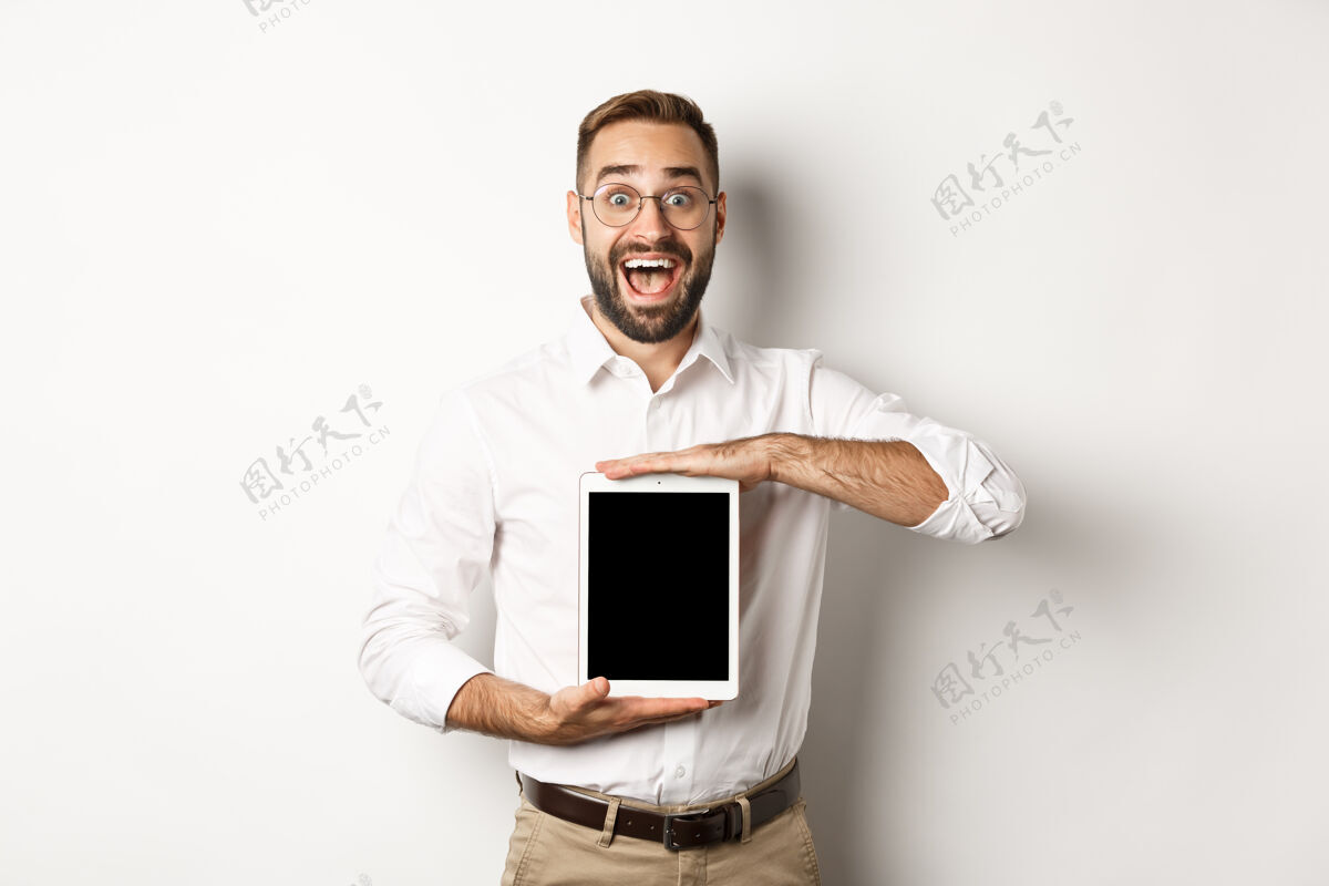 商人兴奋的男子展示数字化平板电脑屏幕 微笑着惊叹 站着显示器雇主老板