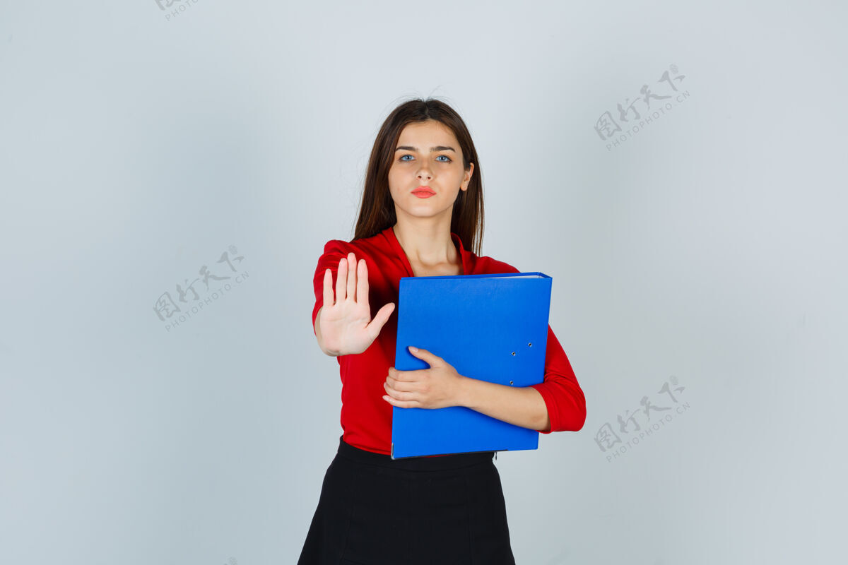 文件夹照片中的年轻女士拿着文件夹 穿着红色上衣做着停车手势女性严肃举行