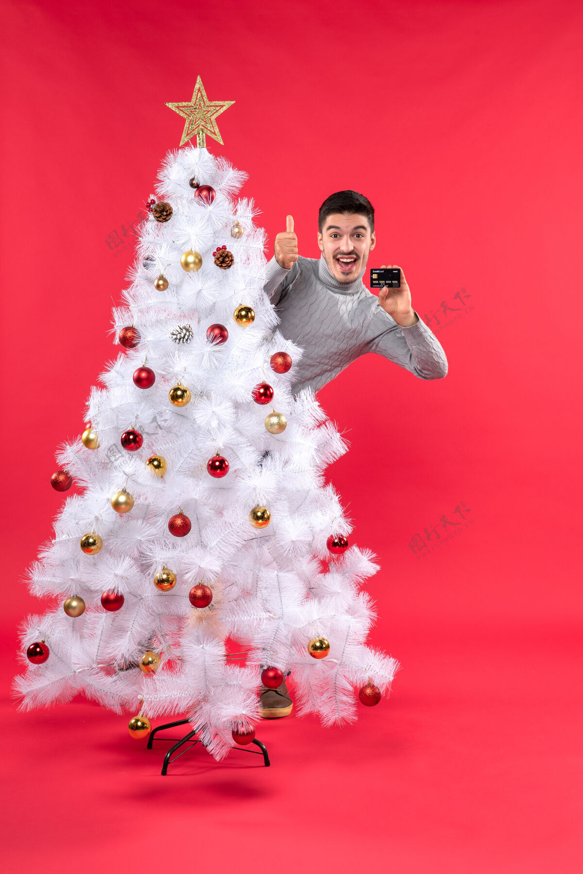 帽子圣诞气氛 情绪激动的家伙站在装饰好的圣诞树后面 做着ok的手势雪人圣诞装饰