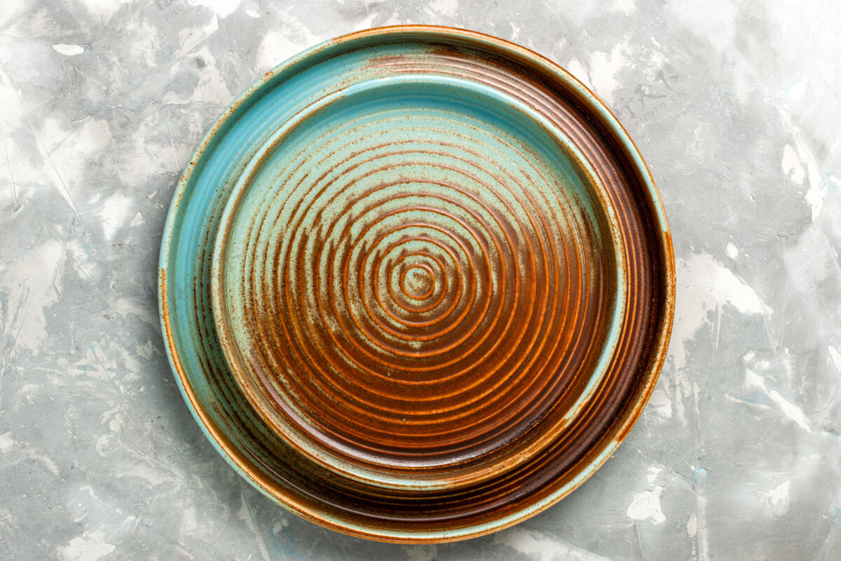 运动浅灰色表面上的圆形棕色空平底锅俯视图圆形餐具厨房
