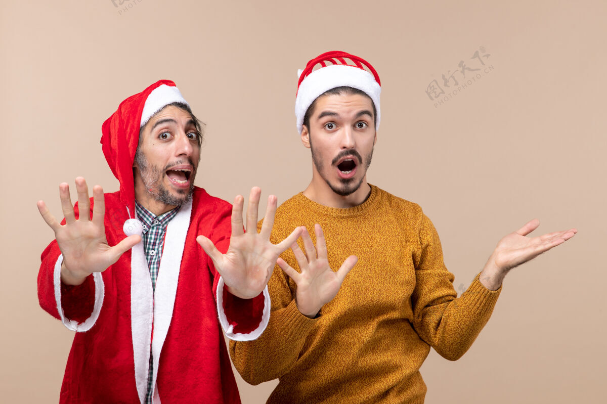 成人正面图两个惊讶的男人在米色孤立的背景上张开他们的手两个惊讶的男人男人两个