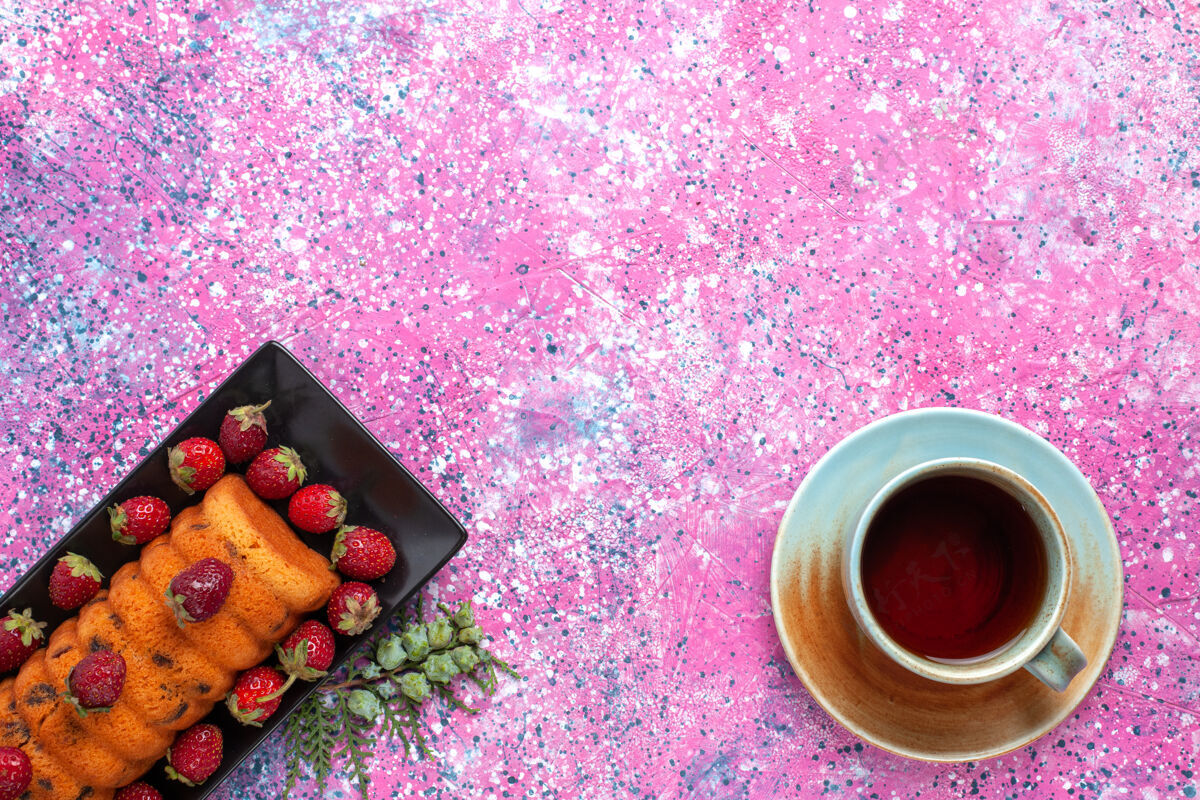 糖在粉红色的桌子上 可以俯瞰美味的蛋糕 红色草莓和一杯茶红色美味水果