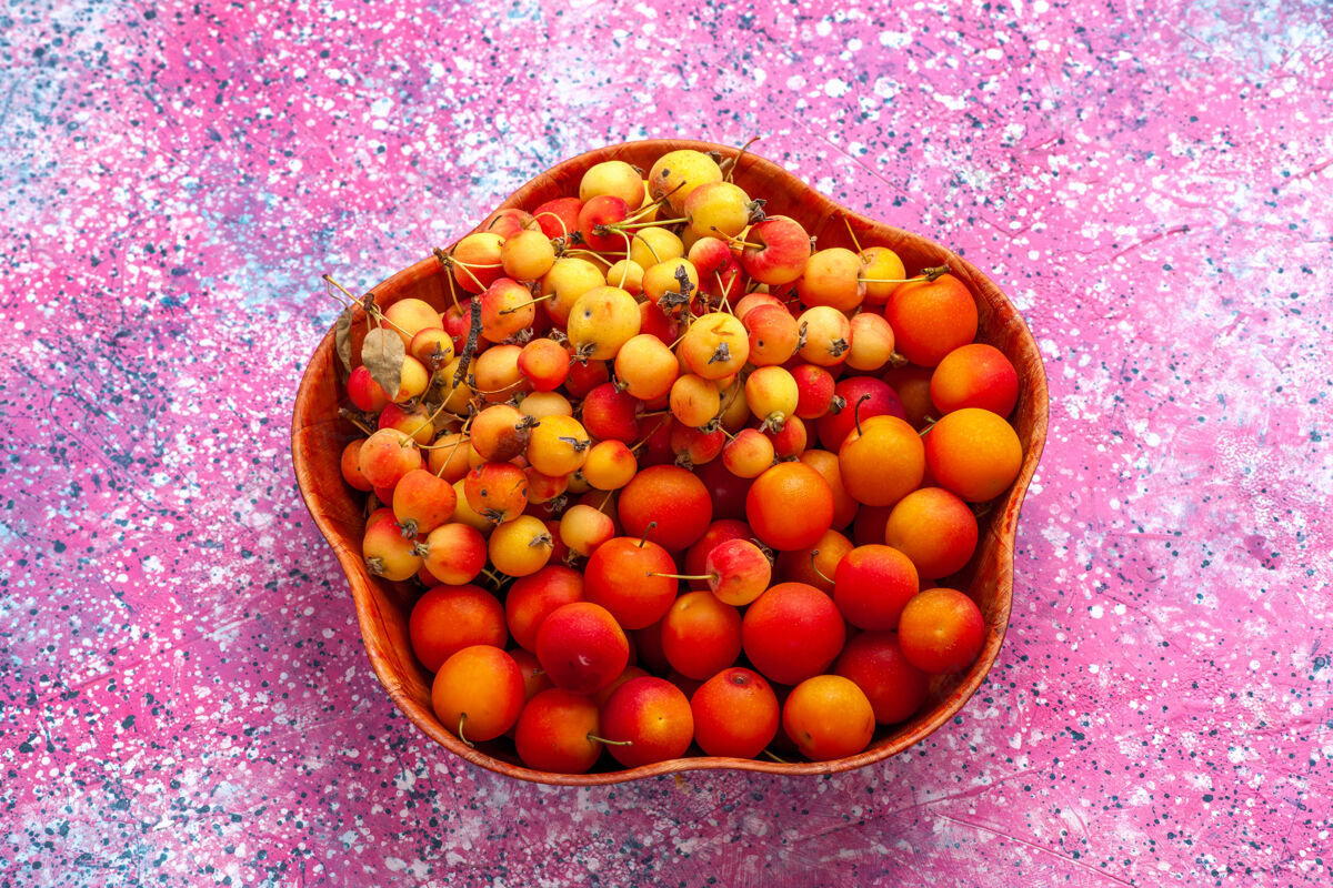 水果半顶视图新鲜的甜樱桃和李子放在粉红色桌子的盘子里盘子李子食物