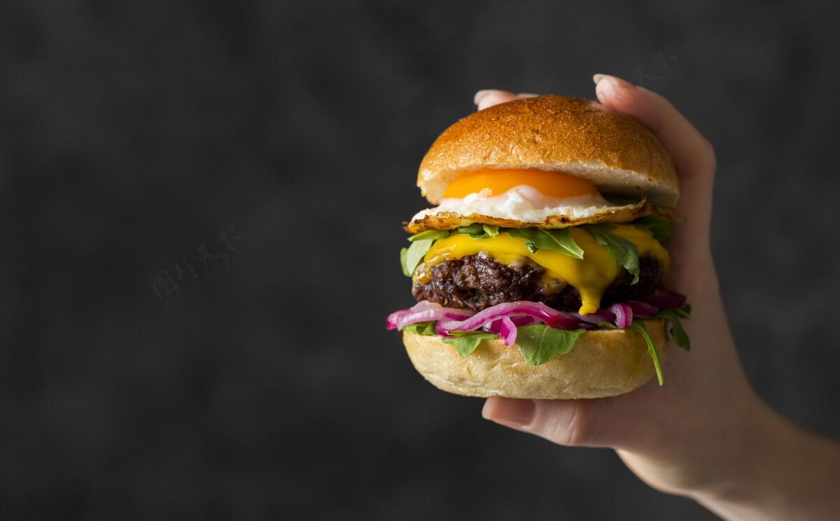 汉堡包前视图手握汉堡与复制空间小吃芝士汉堡膳食