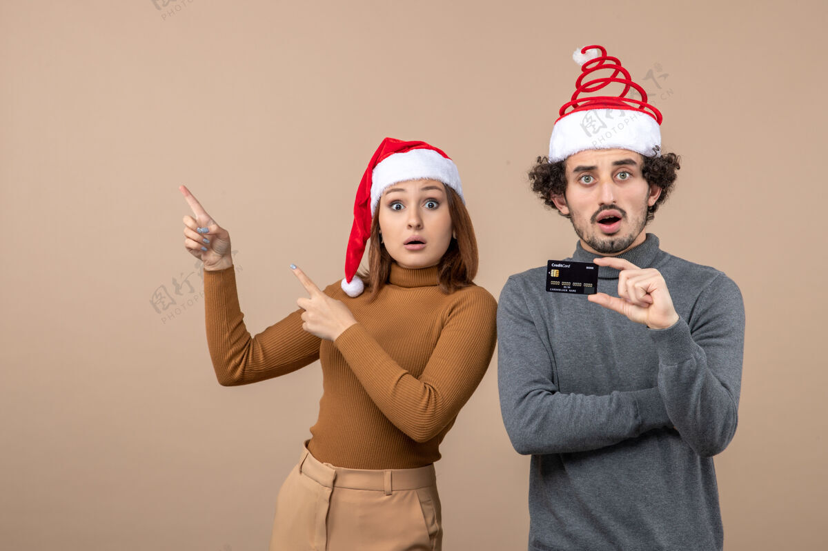 帽子圣诞节心情激动好奇酷情侣戴着红色圣诞老人帽出示银行卡展示人兴奋