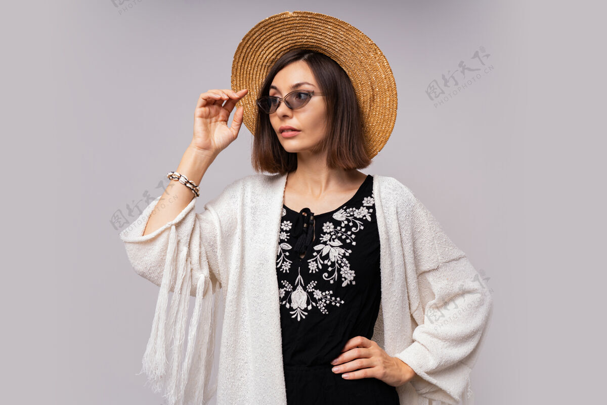 配饰戴着草帽 穿着波西米亚夏装的温文尔雅黑眼睛女孩摆姿势深色瘦身时尚