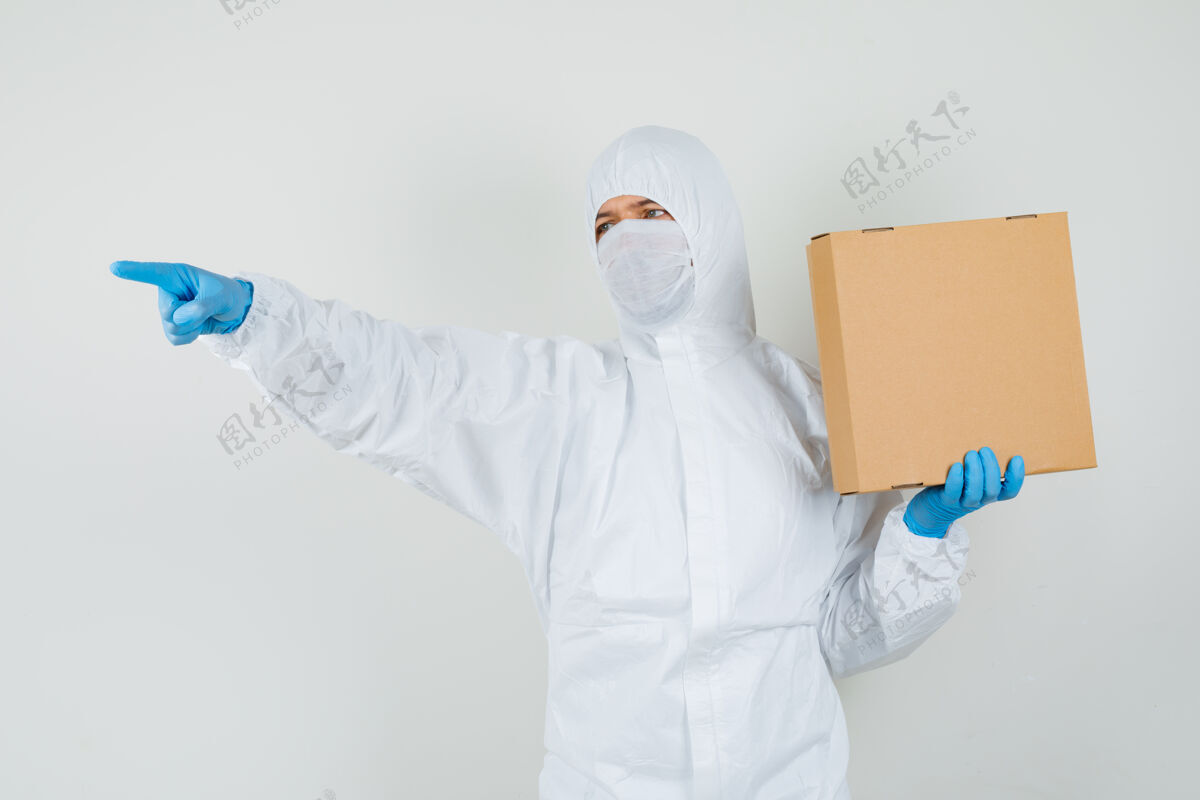 肖像男医生穿着防护服拿着纸板箱指着别处医院手套男性