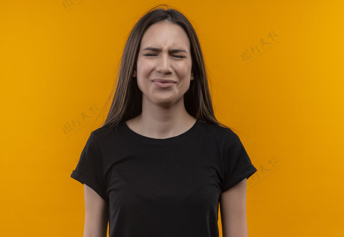 黑色悲伤的年轻白人女孩穿着黑色t恤 在孤立的橙色背景上闭着眼睛穿着悲伤女孩