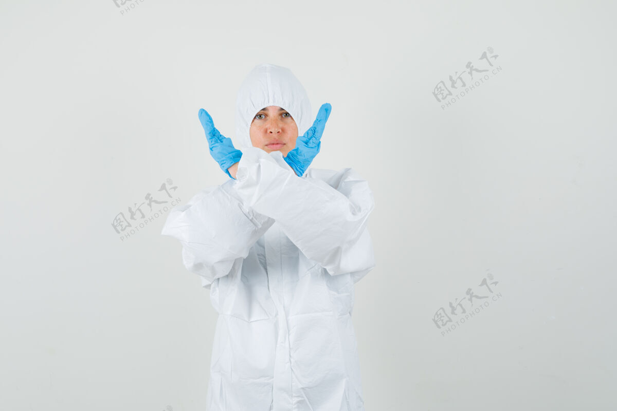 制服女医生穿着防护服 戴着手套 摆出停止的姿势 表情严肃年轻人成人妇女