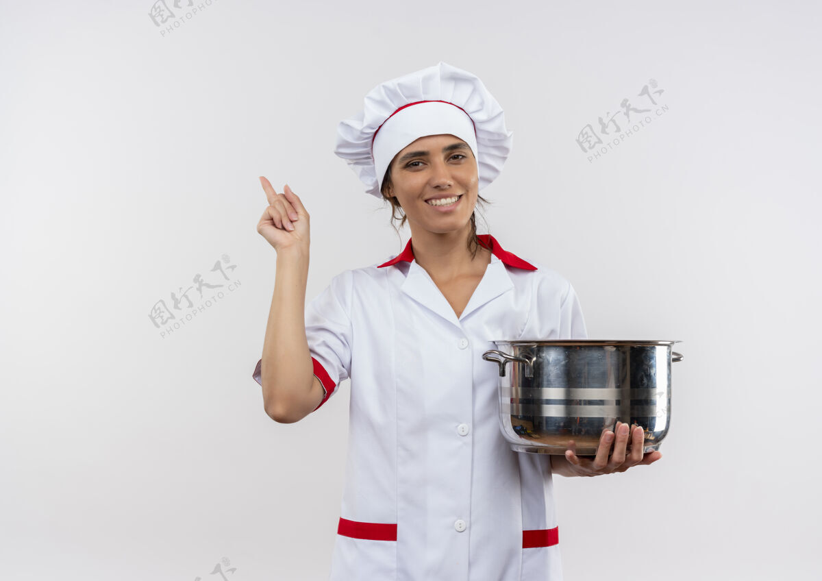 点面带微笑的年轻女厨师穿着厨师制服拿着平底锅 指着旁边的复印空间边拿穿