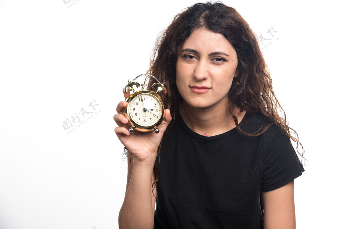 手表睡梦中的女人拿着白色背景的闹钟高质量的照片成人时钟困了