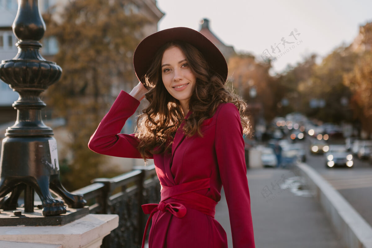 时尚靓丽时尚的紫衣女人走在城市街头 春夏秋冬时节时尚潮流戴着帽子 手拿钱包夹克户外套装