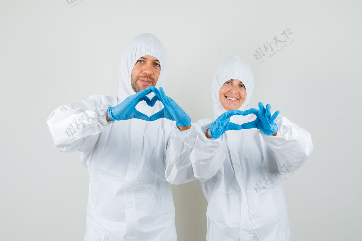 讨论两个医生穿着防护服展示心脏姿势团队交谈疾病