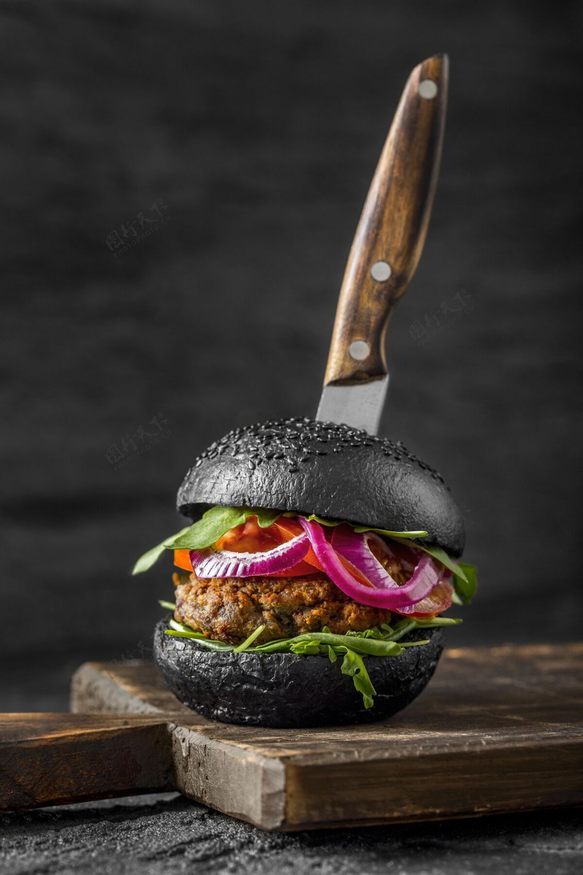 美味前视图蔬菜汉堡包与黑色馒头在砧板与刀垂直吃膳食