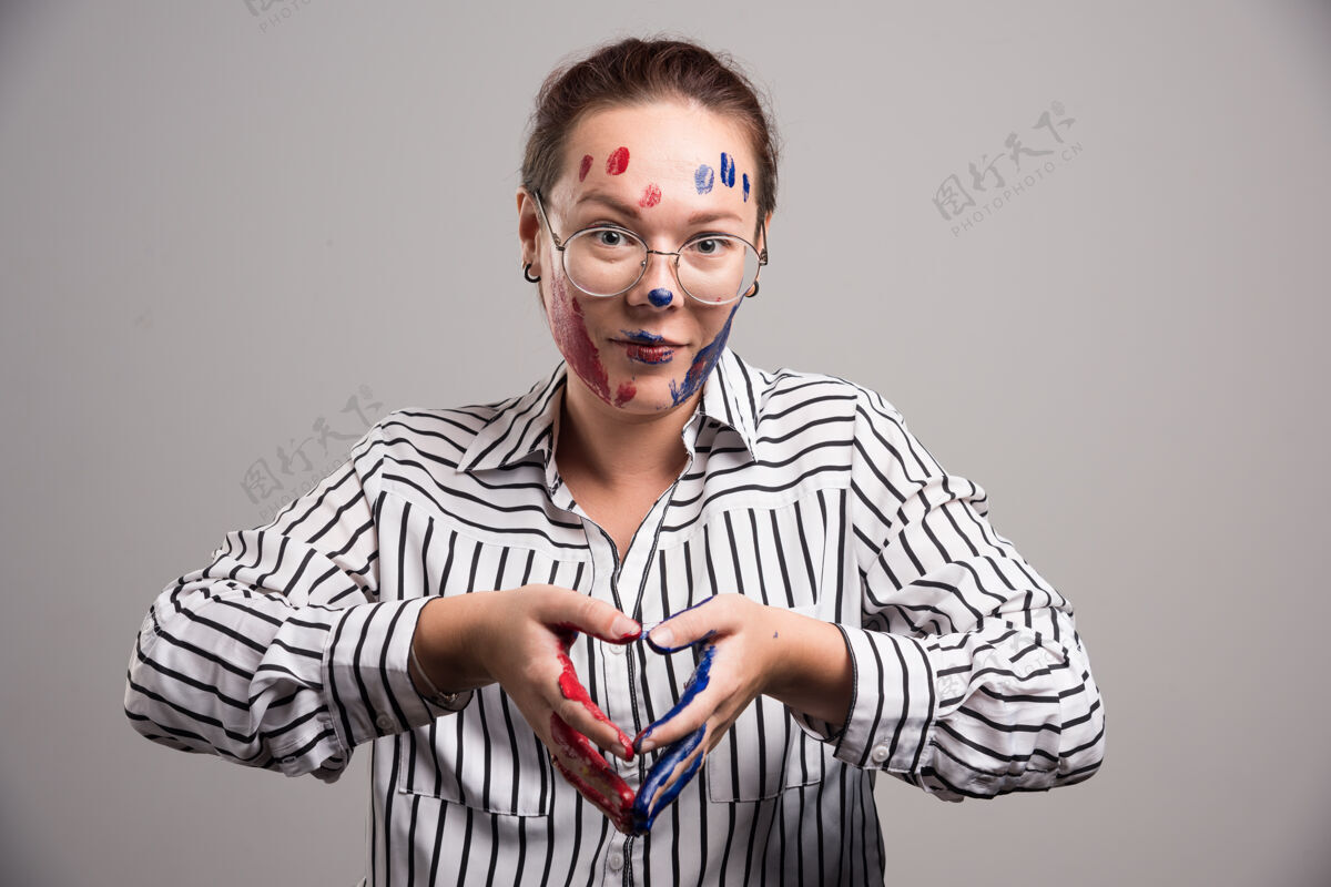 明亮脸上涂着颜料 戴着灰色背景眼镜的女人情感绘画眼镜