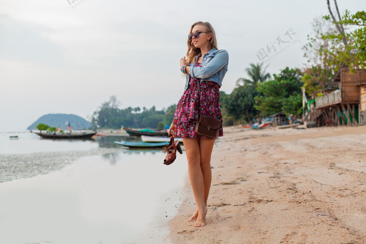 年轻时尚的女人在夏天穿着度假鞋走在沙滩上微笑休闲女人
