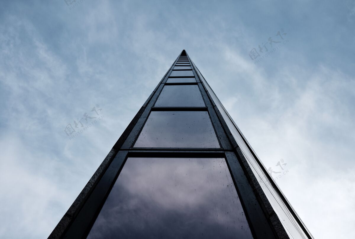 低低角度拍摄的一个高大的现代建筑与多云的天空结构建筑玻璃