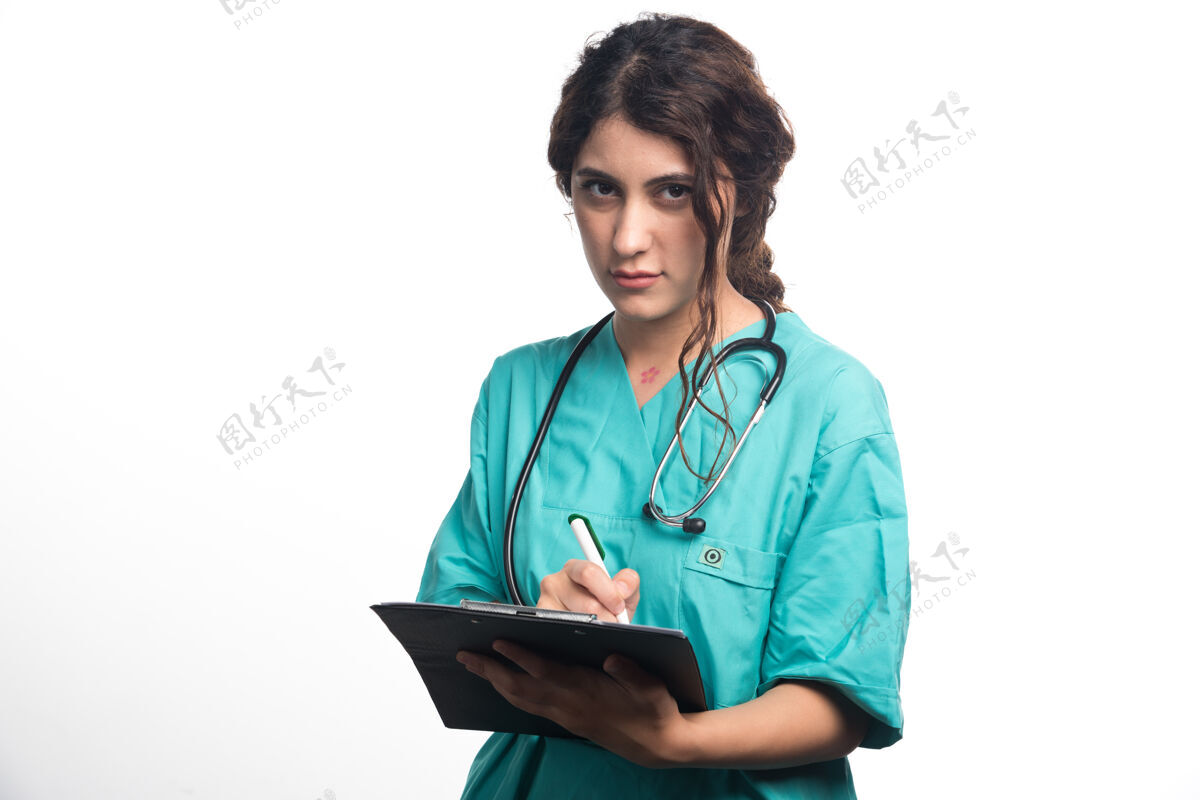女性带听诊器的女医生在白色背景的剪贴板上写东西高质量的照片向上从业者专家