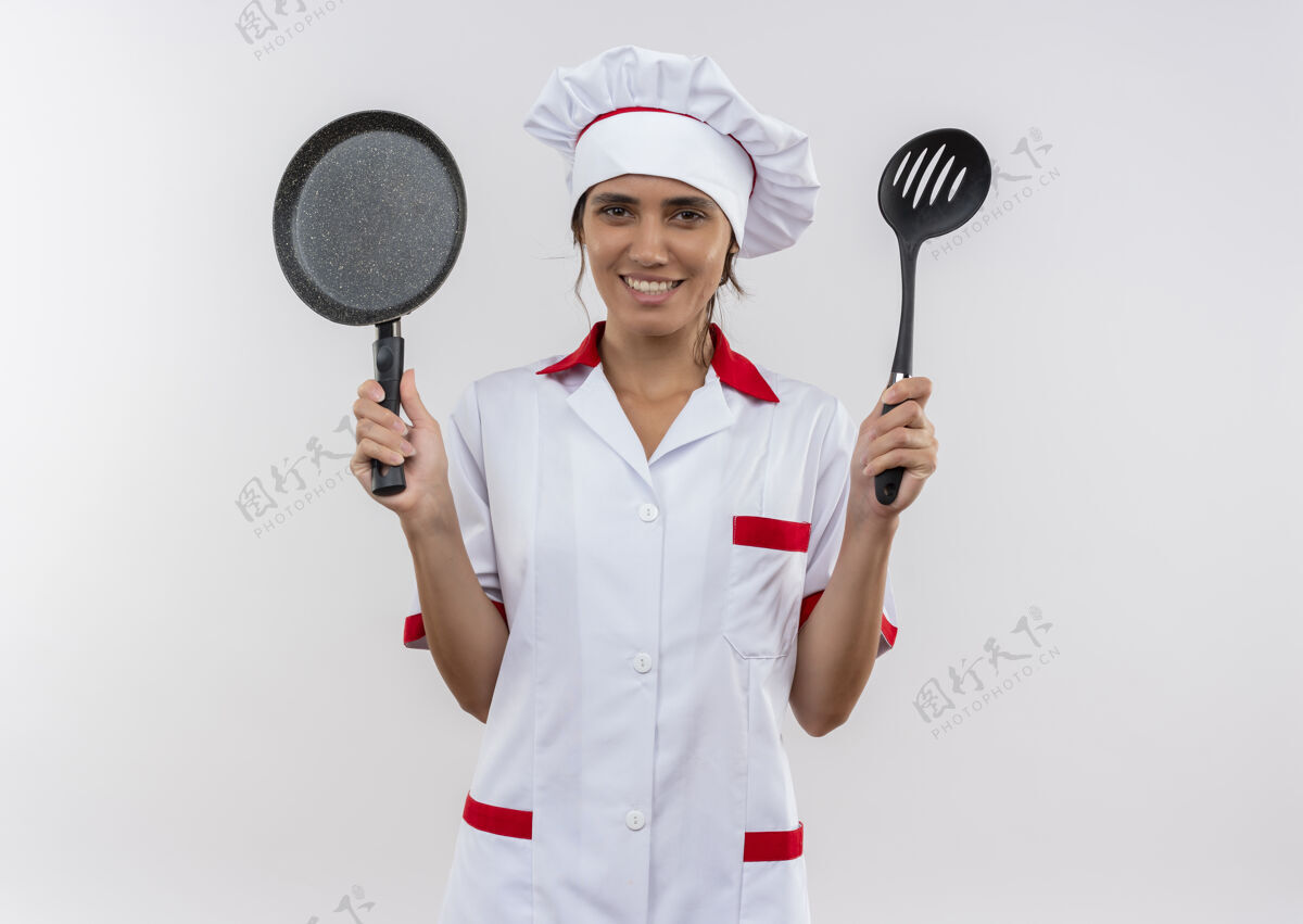 手拿面带微笑的年轻女厨师穿着厨师制服 手里拿着煎锅和抹刀 还有复印空间煎炸女穿