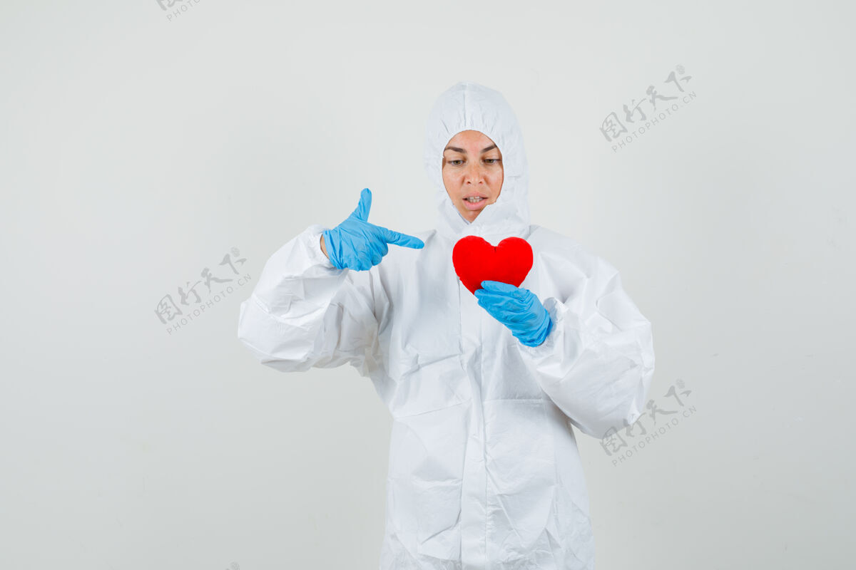 女人穿防护服指着红心的女医生自信健康女人