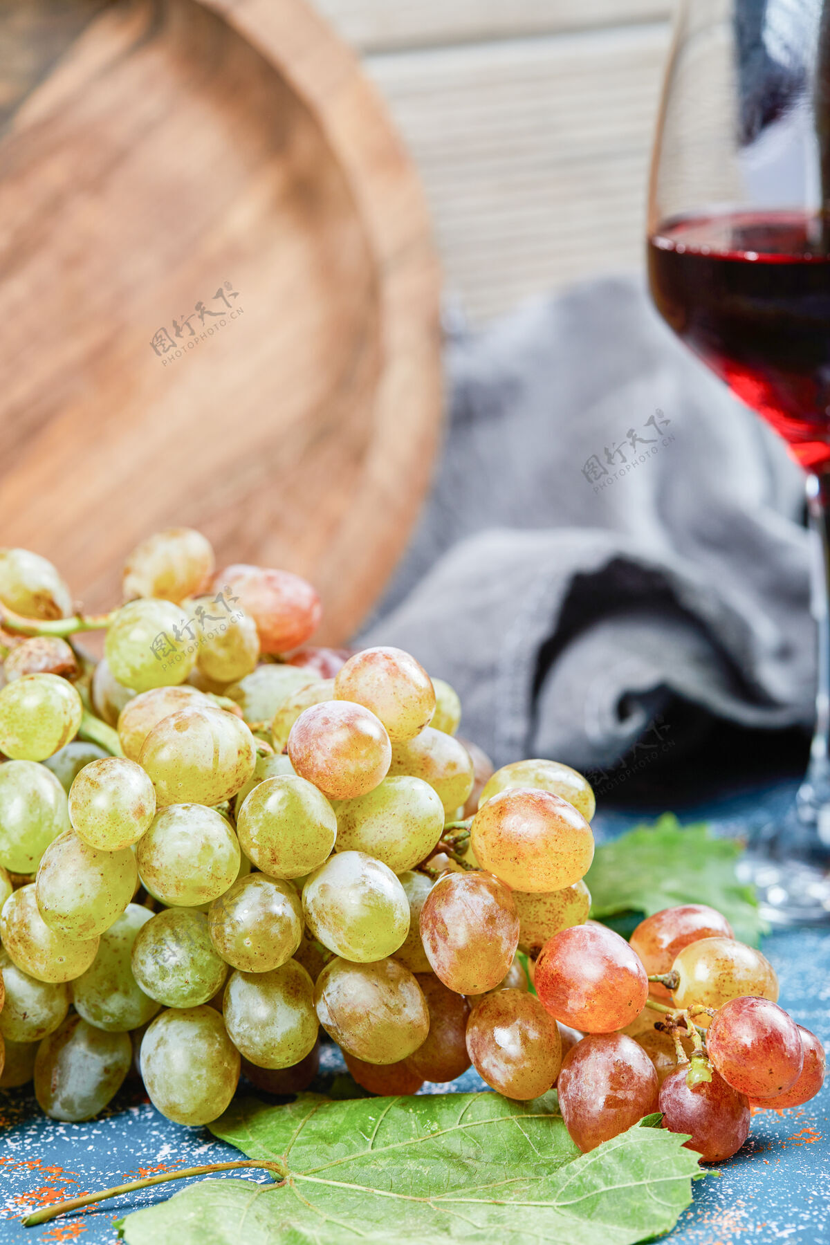 葡萄酒一束葡萄和一杯葡萄酒在蓝色的背景上高品质的照片天然餐桌食品