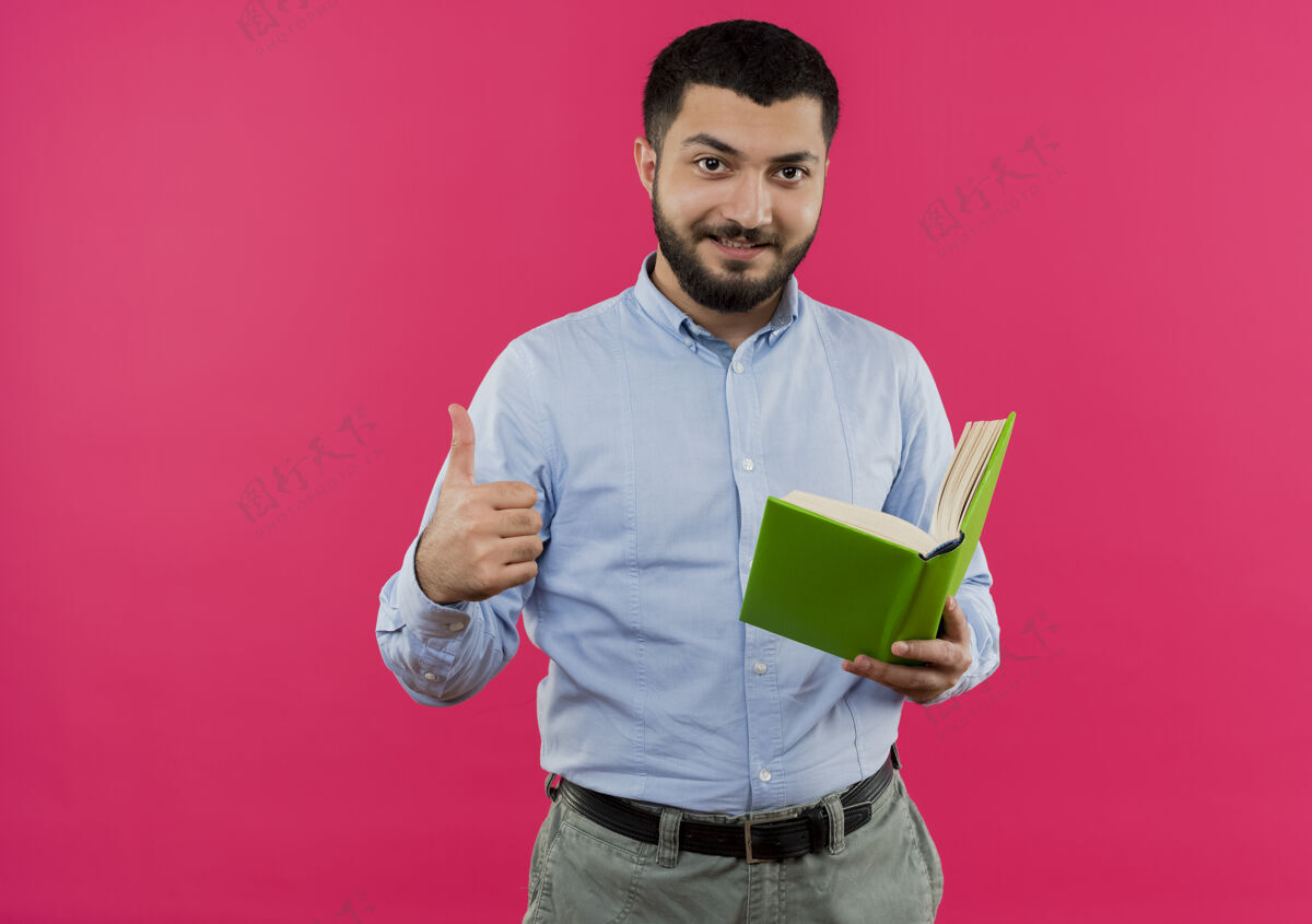 向上身穿蓝衬衫 留着胡子的年轻人拿着书微笑着竖起大拇指蓝色微笑拇指