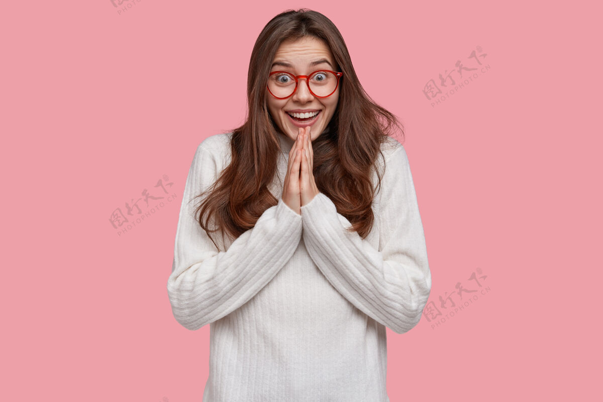 手势幸福女人的照片双手合十祈祷 表情愉悦 穿着白色休闲毛衣学生手衣服