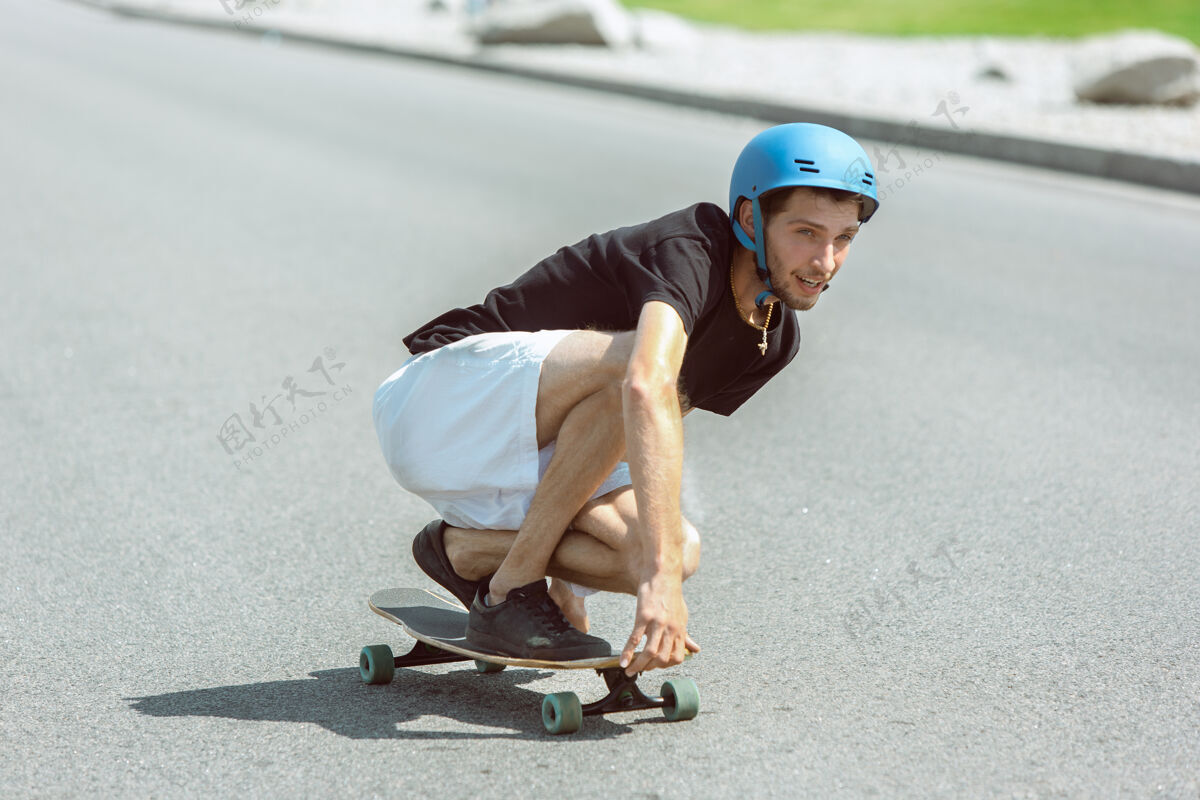 滑板在阳光明媚的日子里 滑板运动员在城市的街道上玩花样街道骑行把戏