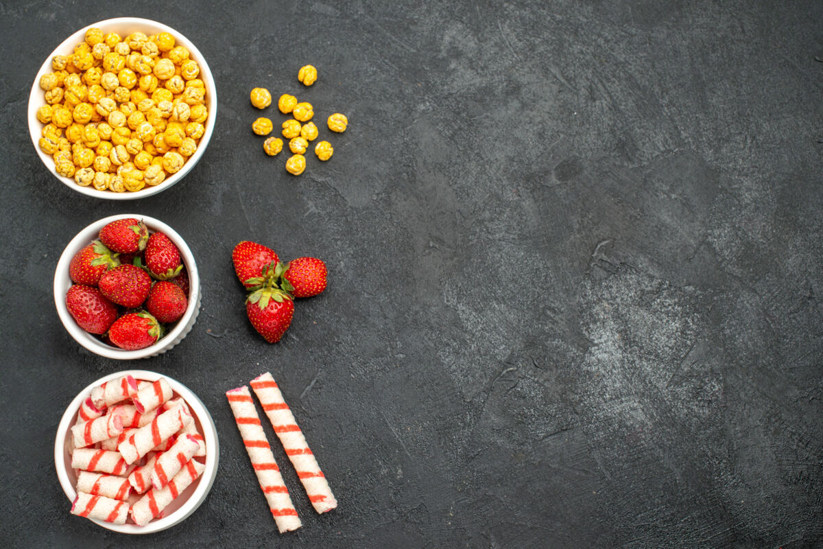 浆果在黑色背景上俯瞰美味的草莓和糖果 并提供免费空间沥青封面甜点