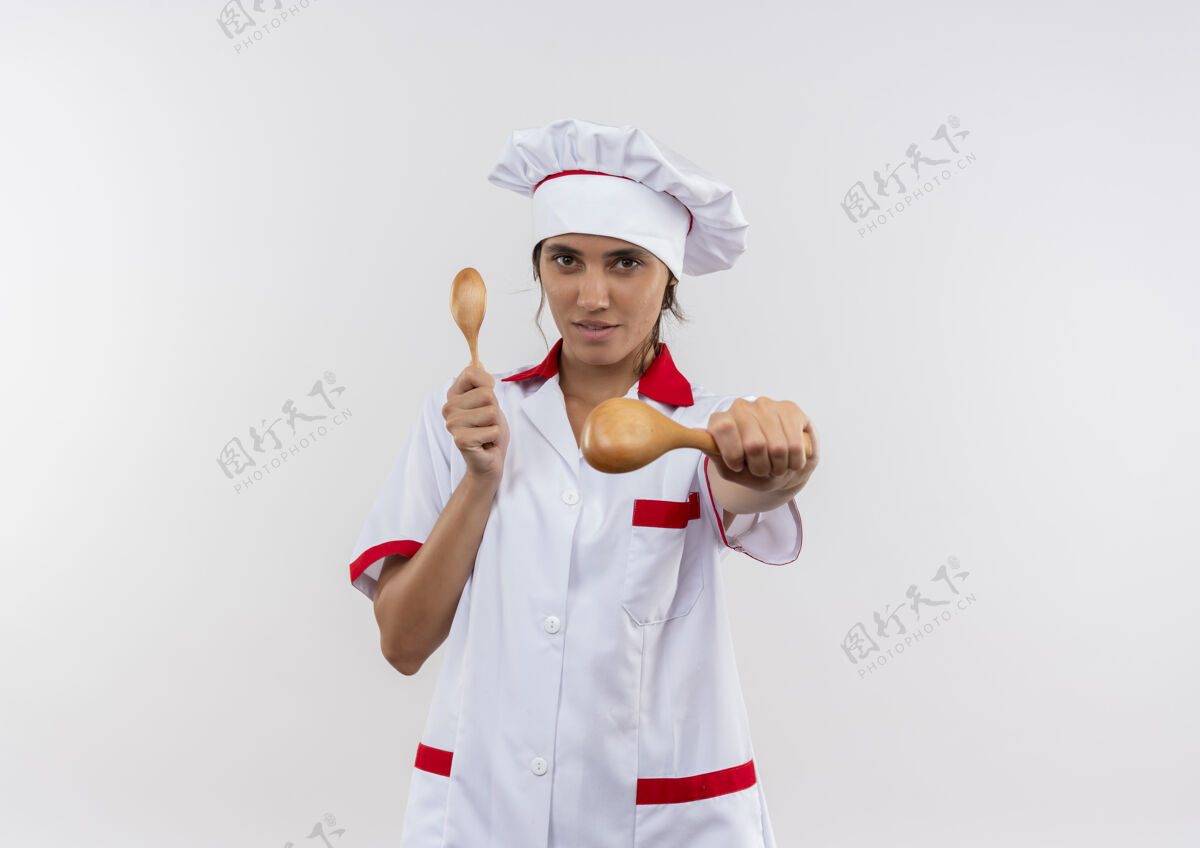 厨师年轻的女厨师穿着厨师制服 拿着勺子站在隔离的白色墙壁上 有复印空间勺子看着戴着